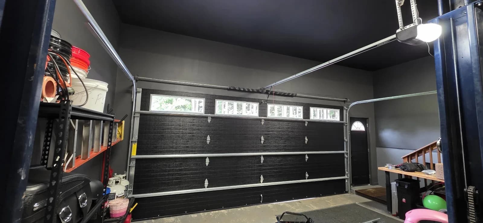 Interior view of a black garage door with a standard ceiling-mounted opener track in Rocky Hill, CT.