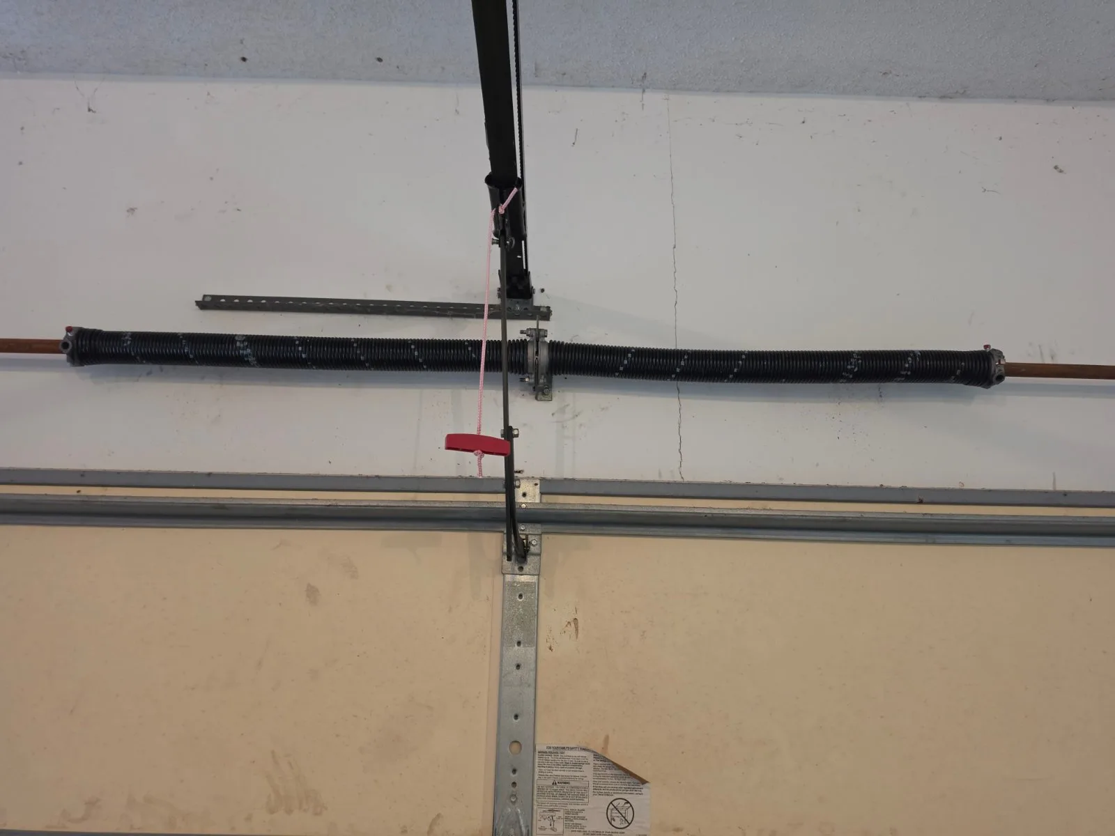 Installed high-cycle torsion spring assembly mounted on a garage door shaft.