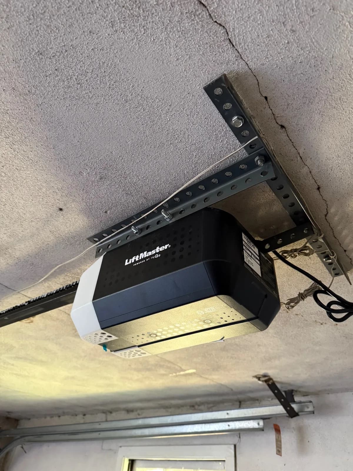 Newly installed LiftMaster garage door opener mounted to overhead garage brackets in Avon, CT.